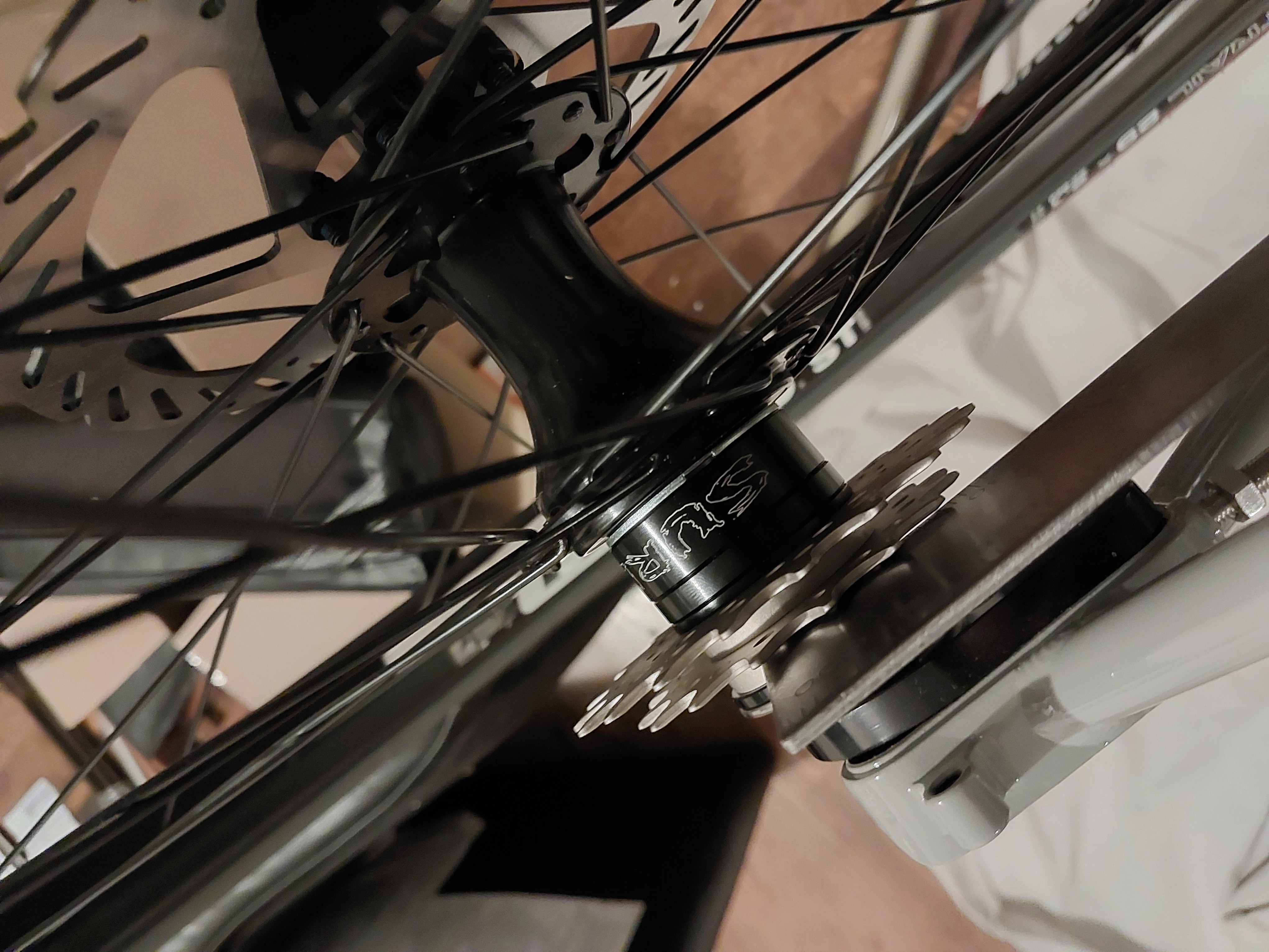 Metal ruler beside cog on rear bike wheel